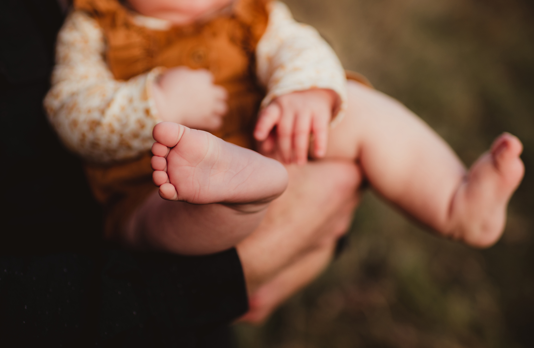 Father holding his daughter with baby toes sticking out