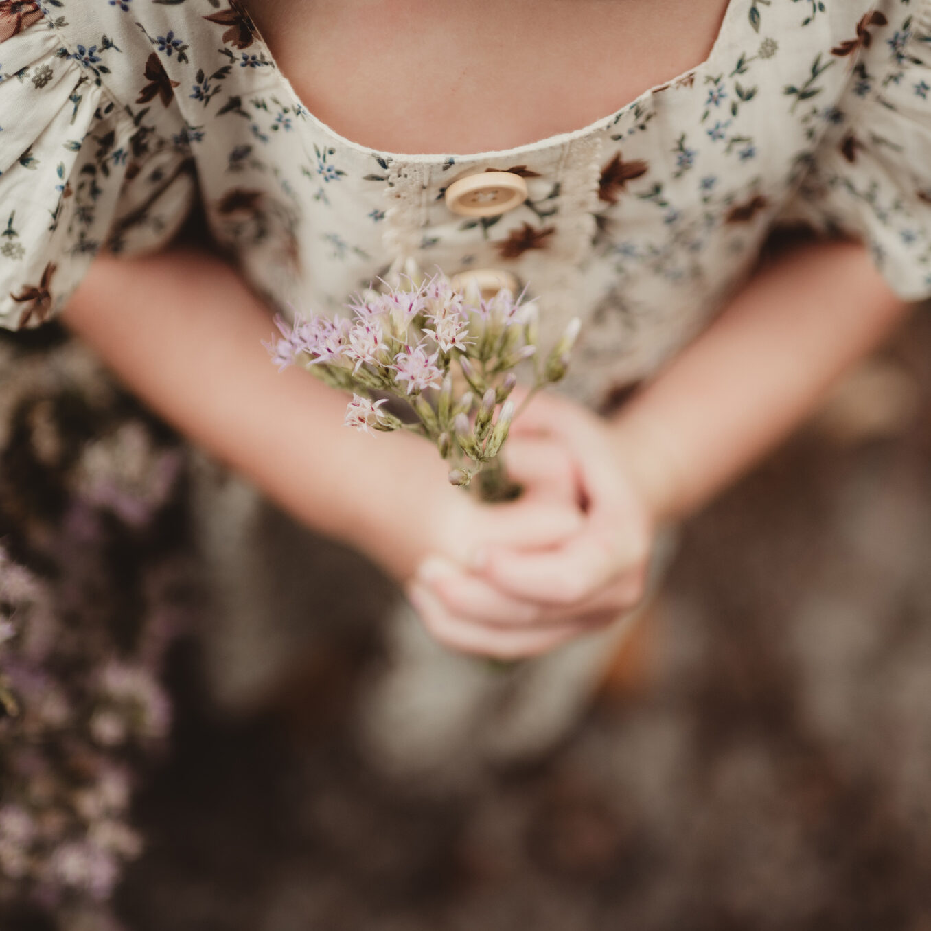 Little girl holding a bunch of flowers in her hands