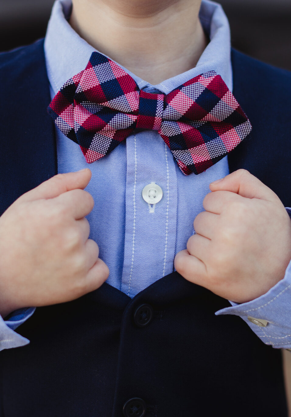 Little boy in vest and bowtie as ring bearer at wedding ceremony